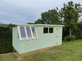 Traditional compact wooden potting shed with half-height glazing and top-opening ventilation window
