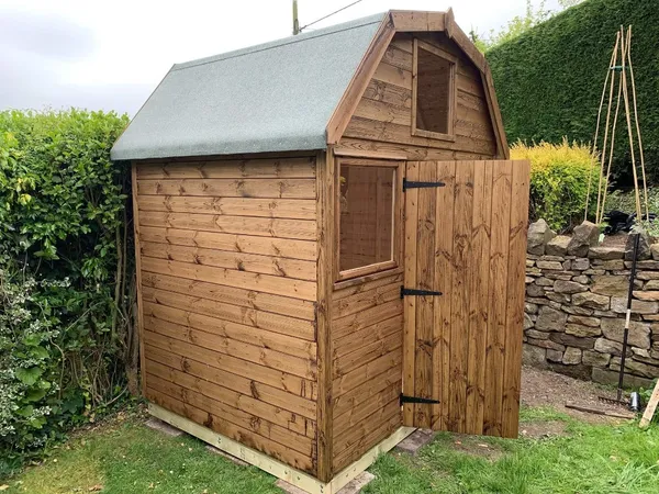 Dutch Barn with gambrel roof and gable window, single door ajar and side window, stained timber