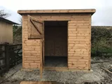 Traditional timber loose box block with pent roof and multiple stable doors