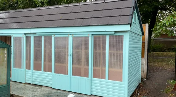 Bespoke painted mint green stock loft with sliding windows and a premium tiled apex roof