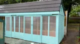 Bespoke painted mint green stock loft with sliding windows and a premium tiled apex roof