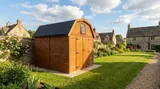 Bespoke Dutch Barn shed with gambrel roof, double barn doors open, light timber cladding on concrete base