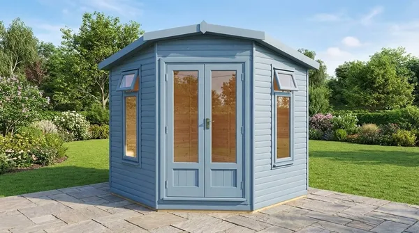 The Haven Corner Summerhouse with green shingle roof in a garden corner