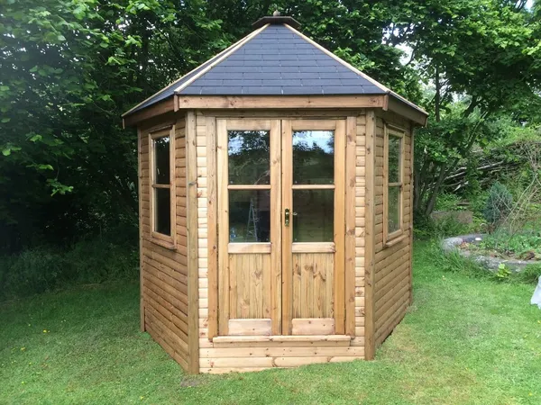 The Panoramic Octagon Summerhouse with felt shingle roof and Georgian-style doors on patio