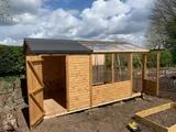 Interior of a timber potting shed with integrated slatted potting bench, angled windows and heavy-duty timber framing