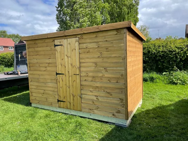 Bespoke pent roof tool shed alongside a boundary line with heavy-duty T-hinges