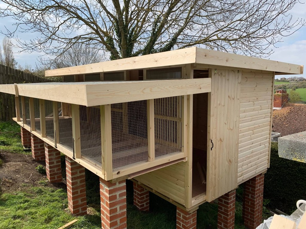 Bespoke pigeon loft built on customer's brick pillar design – timber and mesh sections, raised on custom brick piers, UK racing loft